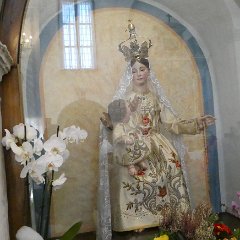 P1180471    Statua della Vergine col Bambino, entrambe in preziosi abiti di seta ricamati da una suora di clausura amica del Santuario.